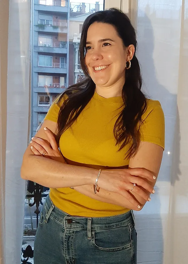 Irene Arilla apoyada en una ventana sonriendo a cámara